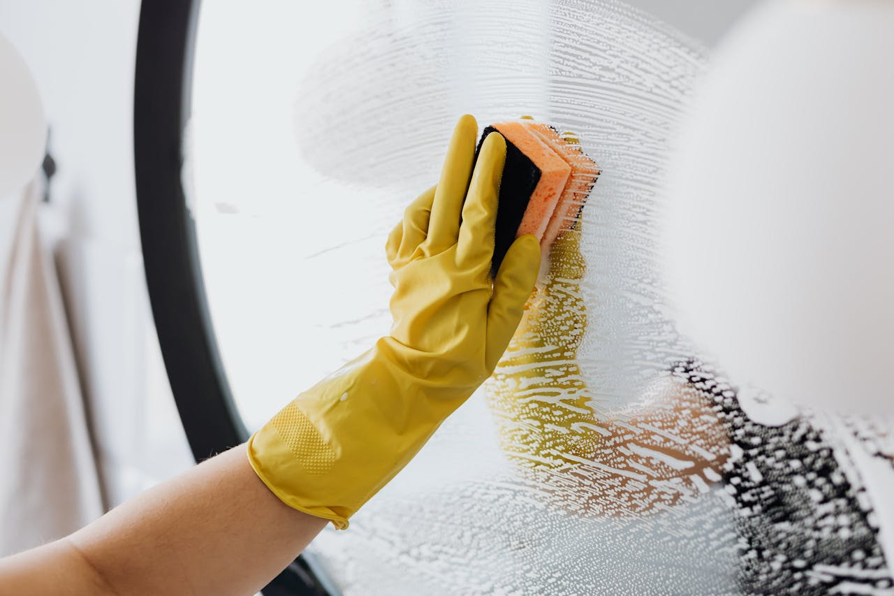 Crafting Captivating Headlines: Your awesome post title goes here Anonymous person in yellow rubber gloves using simple sponge for cleaning mirror in bathroom